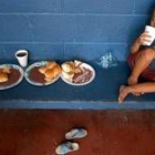 Un niño recibe sus alimentos en un colegio transformado en albergue