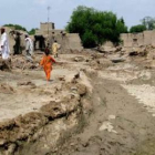 Supervivientes de las inundaciones observan las ruinas de su pueblo, destrozado por las lluvias.