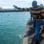 Una persona migrante lanza al mar en Lanzarote una flor en homenaje a los fallecidos en pateras y cayucos. JAVIER FUENTES