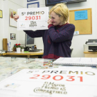 La propietaria de la administración muestra el 29031, premiado con uno de los quintos premios.
