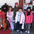 Un grupo de niños y niñas entregan sus cartas al cartero real en Cistierna