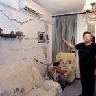 Una vecina muestra los  desperfectos en el salón de su casa, marcada como inhabitable.