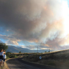 Dos mujeres observan la columna de humo a la salida de Lucillo