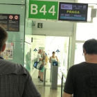Pasajeros que esperan embarcar en el vuelo OK-689 de Czech Airlines observan como los que llegan no pueden acceder al hall de El Prat, pues no hay nadie que les abra la puerta.