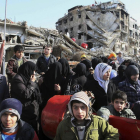 Decenas de sirios hacen cola para recibir comida en las afueras de Damasco.