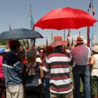 Varias personas se protegen con paraguas en el campo en Jiménez de Jamuz