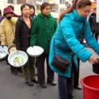 La población tiene que hacer largas colar para conseguir el agua