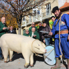 Un matarife lleva al cerdo de corcho al centro cultural, donde se reparte picadillo en una matanza incruenta.