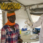 Un trabajador sanitario comprueba el estado de varias personas en la frontera de Nimule, en Uganda.