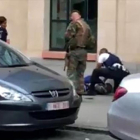 Dos policías y un militar, junto al hombre abatido ayer en Bruselas.