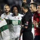 Muñiz Fernández, rodeado de jugadores del Elche tras pitar el penalti a Pepe.