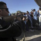 Un policía jordano trata de controlar a la multitud que buscaba trabajo en el aeropuerto.