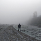 Un hombre camina entre la helada y la niebla en el Bierzo. CÉSAR SÁNCHEZ