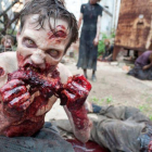 Uno de los zombis de la serie The walking dead, devorando a una de sus víctimas.