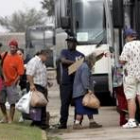 Un grupo de personas evacuadas sube con sus escasas pertenencias a un autobús en Lake Charles