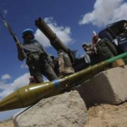 Un misíl yace sobre el suelo cerca de soldados rebeldes libios en Ajdabiya.