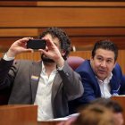 Luis Mariano Santos (UPL) contempla a José Sarrión (IU) fotografiando las pantallas con el resultado de la votación. MIRIAM CHACÓN