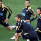 Llorente, Juanito, Mata y Piqué hacen ejercicios de estiramiento en un momento de la sesión preparat