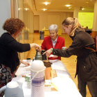 Voluntarios sirven un café a una ciudadana.