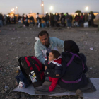 Refugiados esperan a un tren entre Grecia y Macedonia.