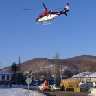 U helicóptero de la Junta carga paja y pienso en la carretera de Prioro para trasladar comida al ganado atrapado por la nieve en Tejerina