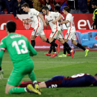 Los futbolistas del Sevilla celebran el empate ante la desolación de los jugadores del Eibar. JULIO MUÑOZ
