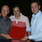 Pepe Ribagorda recibe una placa de manos de Pepe Peñín, con el alcalde de Pajares en el centro.