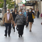 Gente transita por Ordoño II con las mascarillas de uso obligatorio.
