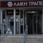 Un hombre habla con un guardia de seguridad en las puertas del Banco Laiki, en Nicosia, antes de su apertura.