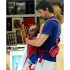 Un padre sujeta con ternura a su hijo en la feria del libro