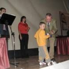 Luis Fuente entrega un regalo a un niño agraciado en el sorteo