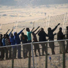 Inmigrantes subsaharianos intentando saltar la valla de Melilla, el pasado mayo.