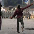 Un manifestante lanza una piedra contra policías venezolanos en la frontera con Brasil, este domingo. Un manifestante lanza una piedra contra policías venezolanos en la frontera con Brasil, este domingo.