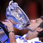 El serbio Djokovic besa su trofeo tras ganar a Murray en la final del Abierto de Australia.