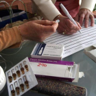 Dos enfermeras preparando los medicamentos para muerte digna en casa de un paciente.