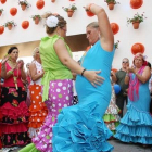 Unas mujeres bailan en un corrillo en el recinto ferial de Málaga, en las fiestas de agosto.