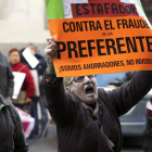 Dos afectados por las participaciones preferentes, durante una de sus protestas.