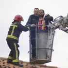 Momento en el que un bombero y un guardia civil ayudan al preso a bajar del tejado.