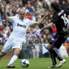 El delantero holandés Arjen Robben, autor ayer de un gol, intenta marcharse del centrocampista Pedro