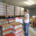 Damián Tascón, del Banco de Alimentos, junto a un operario moviendo cajas donadas.