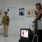 Una mujer posa ante la cámar de video, mientras otra espera su turno para participar en la prueba