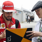 Fernando Alonso firma un autógrafo a un fan en el circuito de Suzuka.