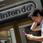 Un hombre juega al Pokémon Go con su móvil frente a la sede de Nintendo en Nueva York, el lunes.