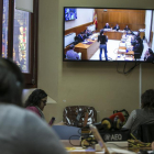 Periodistas siguen la declaración de una testigo por un monitor, en la Audiencia de Barcelona.