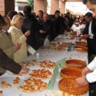 Varios camareros reparten entre los asistentes la tradicional tapa de ajo.
