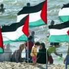 Mujeres y niños palestinos disfrutan en una playa de Gaza en el momento en que se firmó la tregua