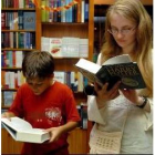 Dos jóvenes lectores ojean un ejemplar del último libro de Harry Potter