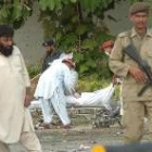 Miembros de seguridad paquistaníes recogen los restos mortales del cuerpo de un terrorista suicida