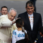 El Papa saluda a uns niños indígenas ante la mirada del presidente de Ecuador, Rafael Correa.
