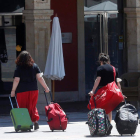 Dos jóvenes arrastran su equipaje por el centro de la ciudad. FERNANDO OTERO PERANDONES